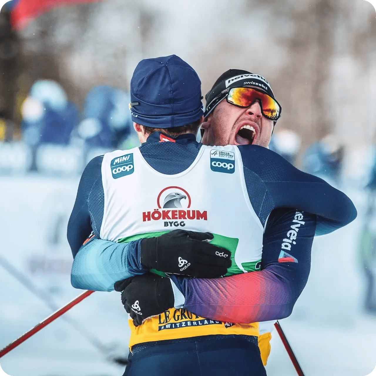 Lyckliga skidåkare kramas i mål under världscupen